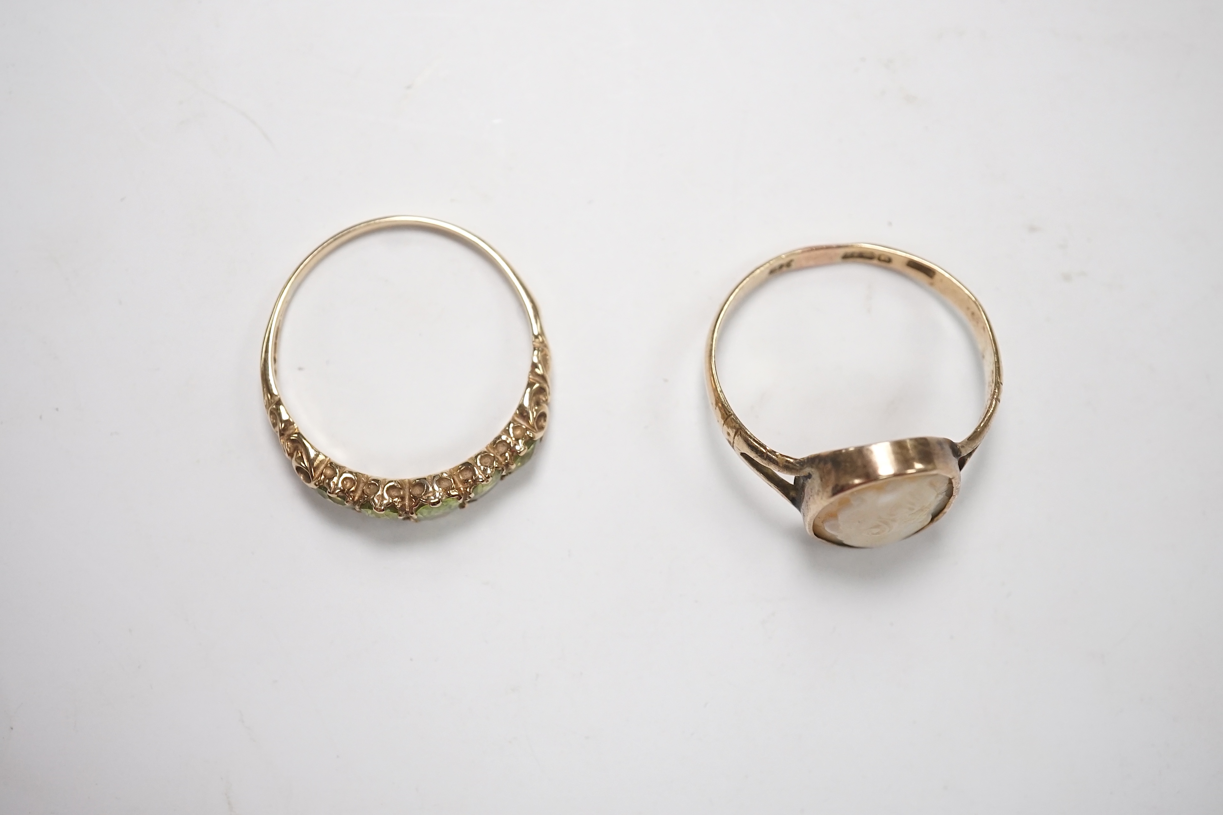 A 9ct and graduated five stone peridot set half hoop ring, size V, a 9ct gold and cameo shell ring and a gem set stickpin. Condition - poor to fair